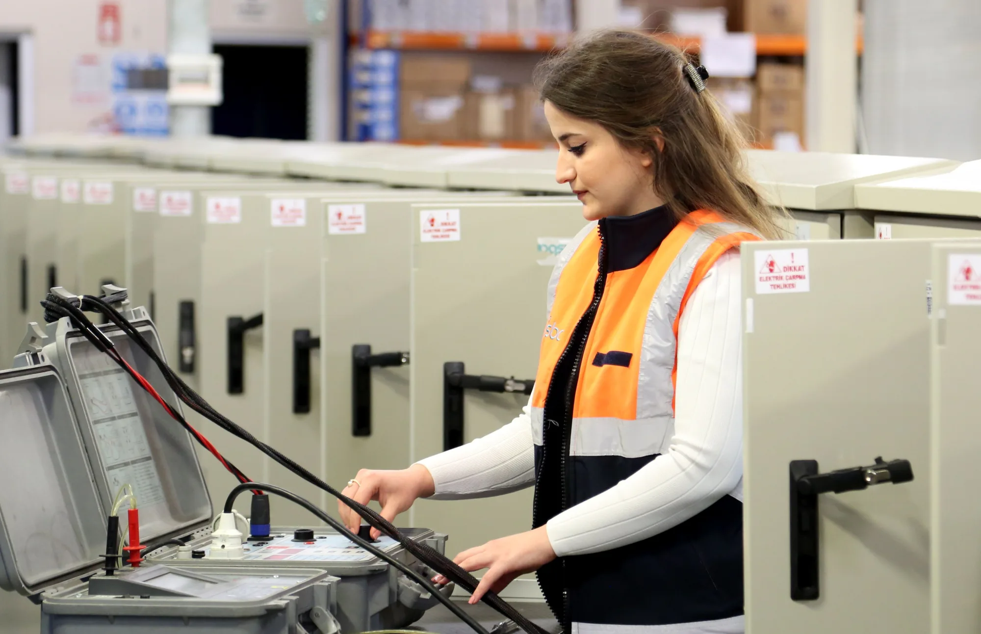 Elektrotechnikerin prüft Anlagen und Messgeräte in einer Schaltzentrale