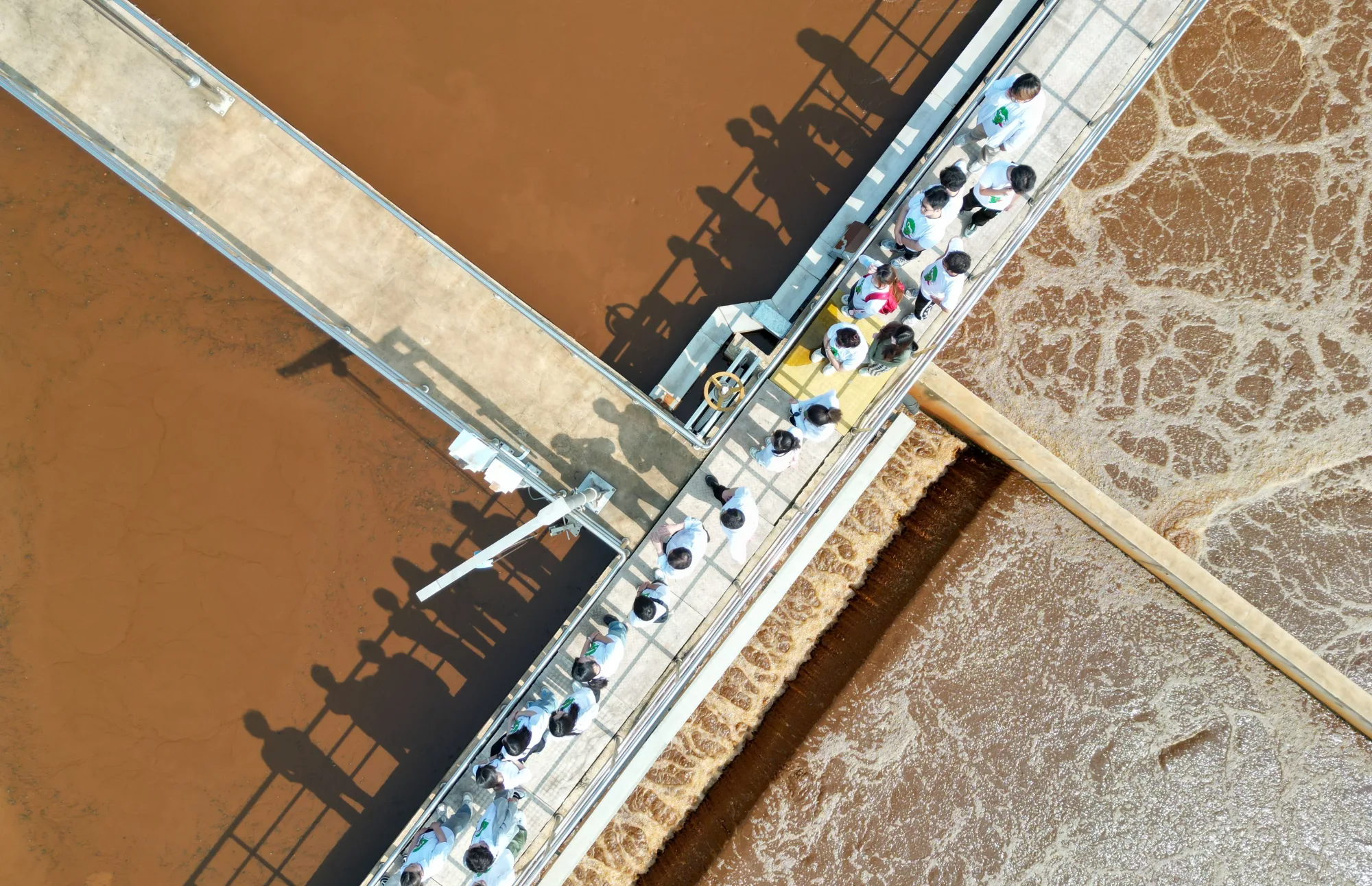 Besuchergruppe überquert die Becken einer industriellen Wasseraufbereitungsanlage