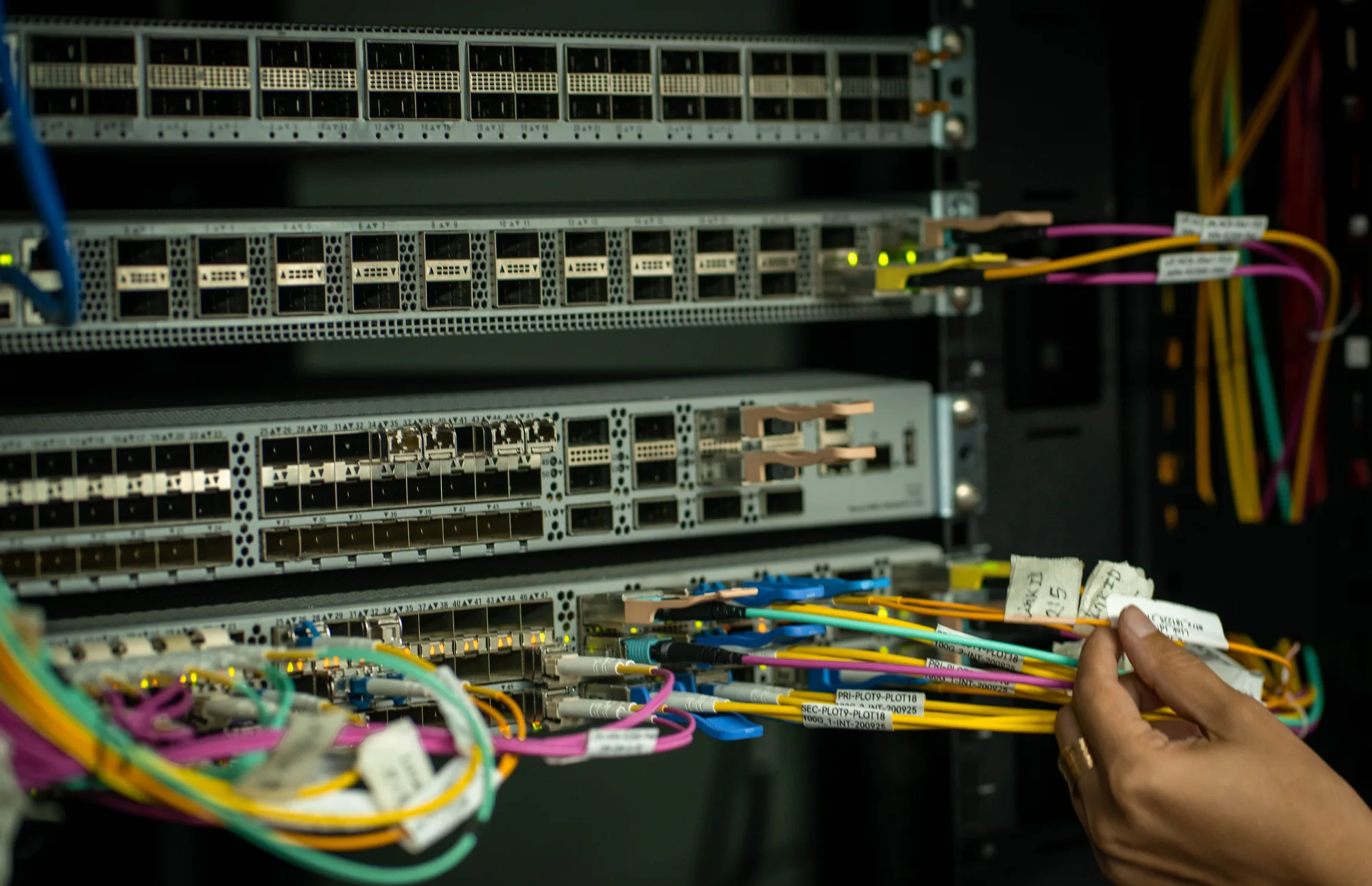 Hand ordnet Glasfaserkabel in einem Serverraum