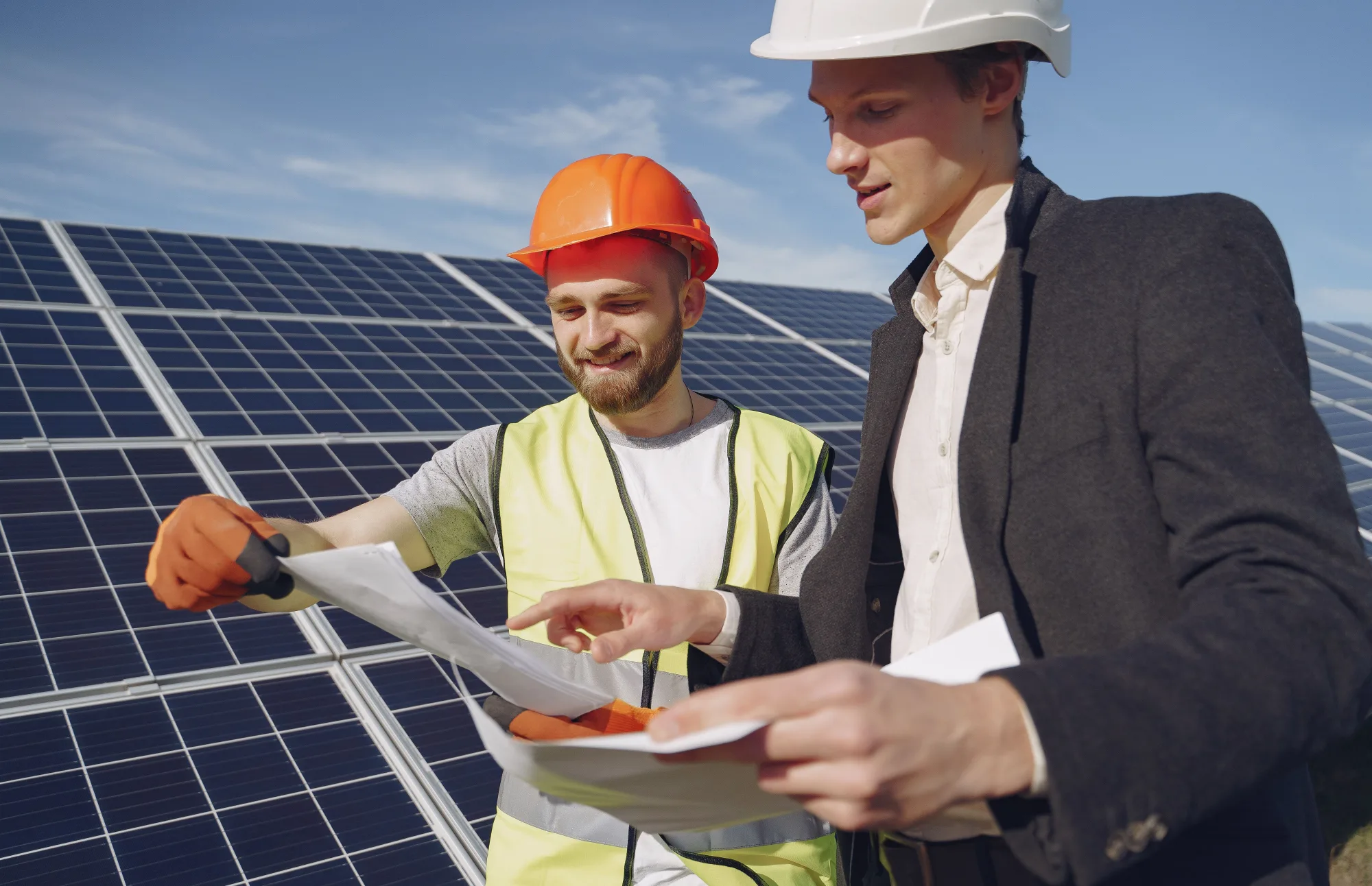 Zwei Fachleute besprechen Projektpläne vor einer Solaranlage
