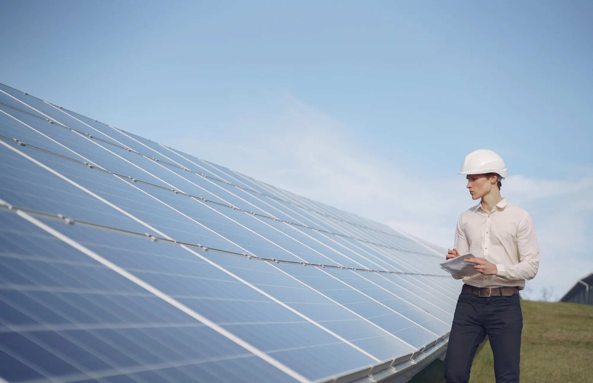 Eine Fachkraft prüft Solarmodule mit einem Klemmbrett