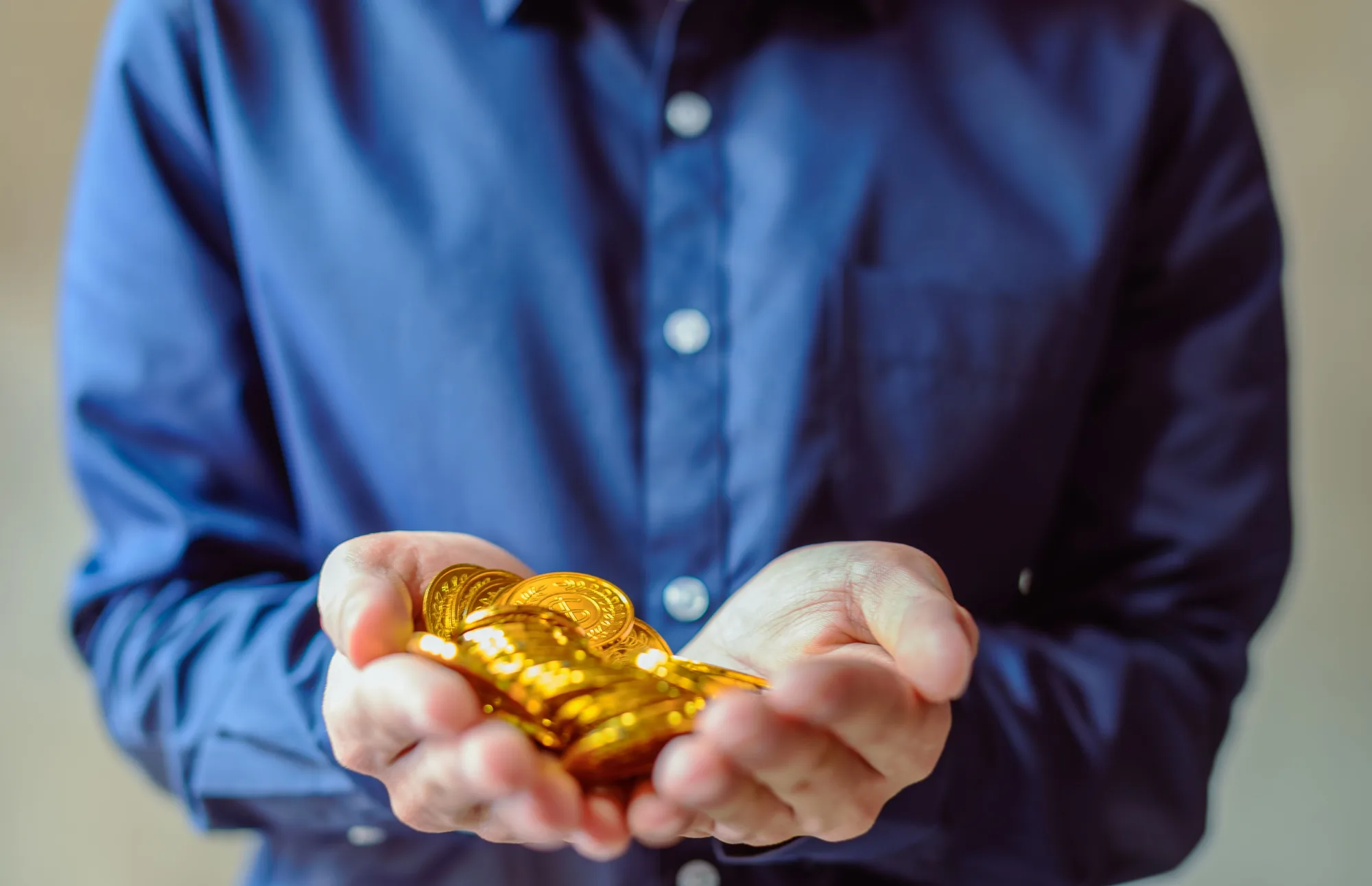 Ein Anleger hält Goldstücke als Teil seiner Geldanlage