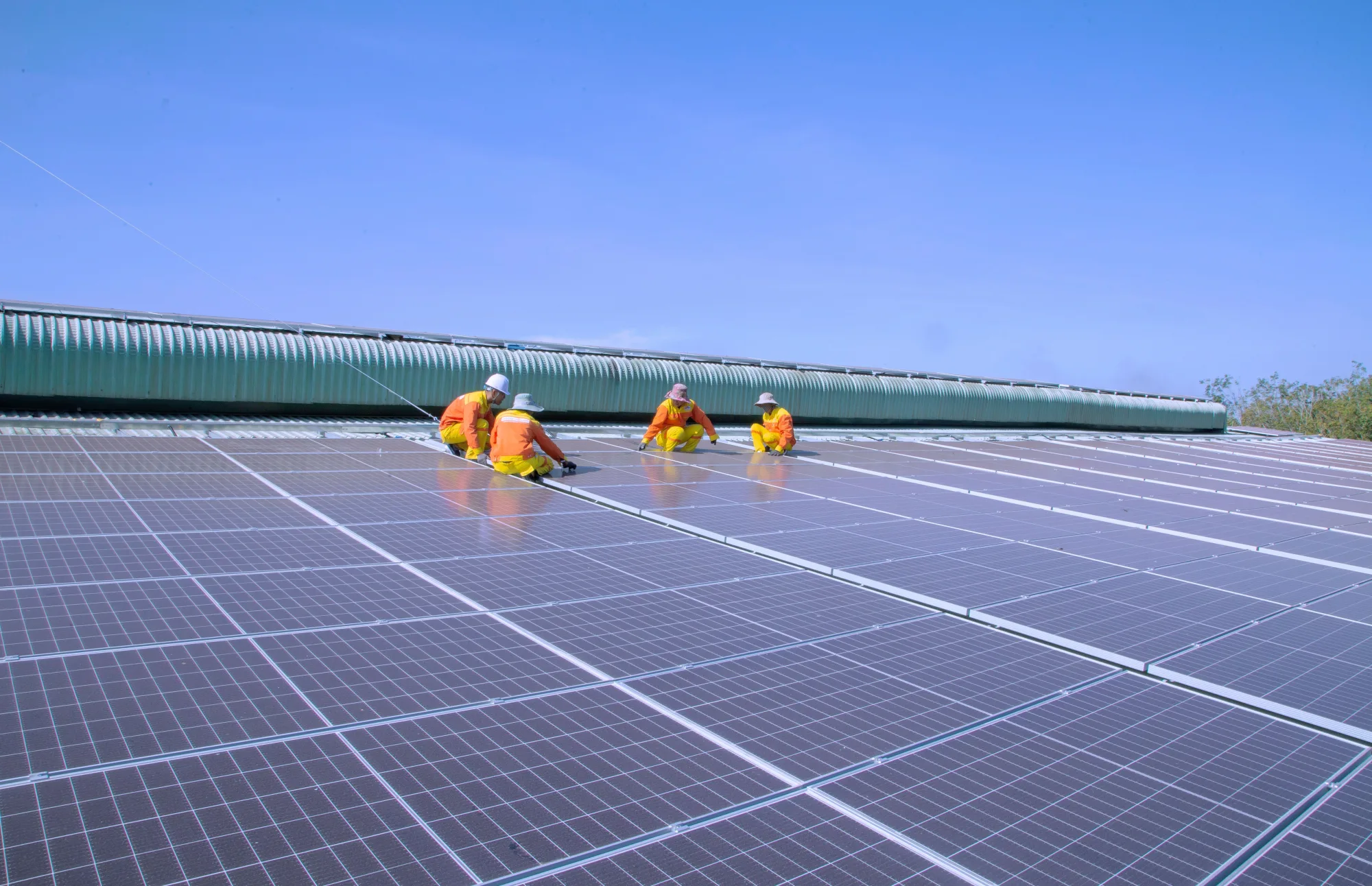 Fachkräfte montieren Solarmodule auf einem großen Dach
