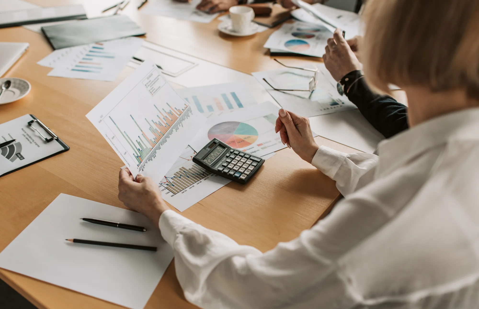 Ein Team analysiert gemeinsam Finanzdiagramme an einem Tisch.