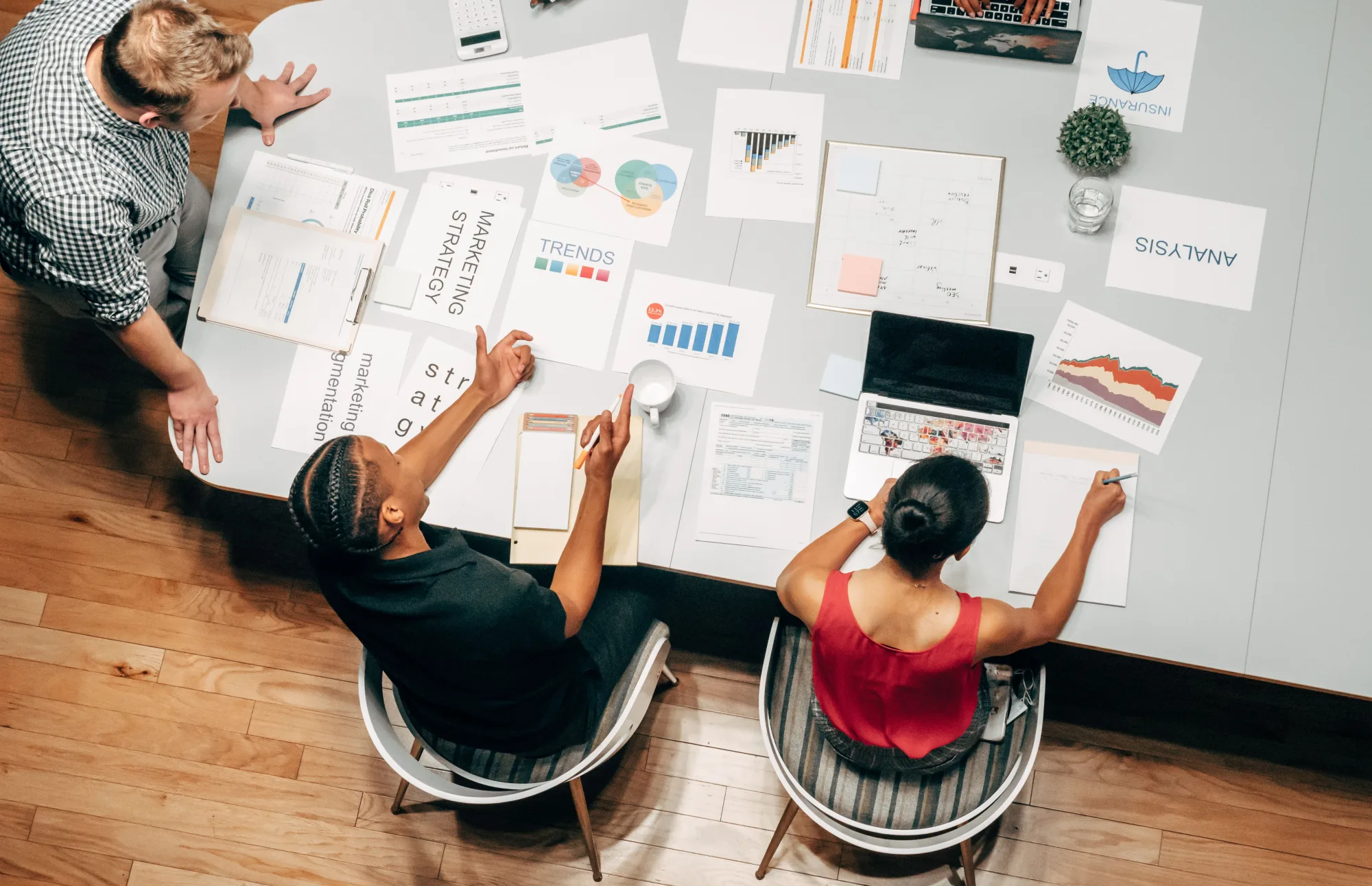 Ein Analystenteam bespricht Daten und Strategien an einem Tisch.