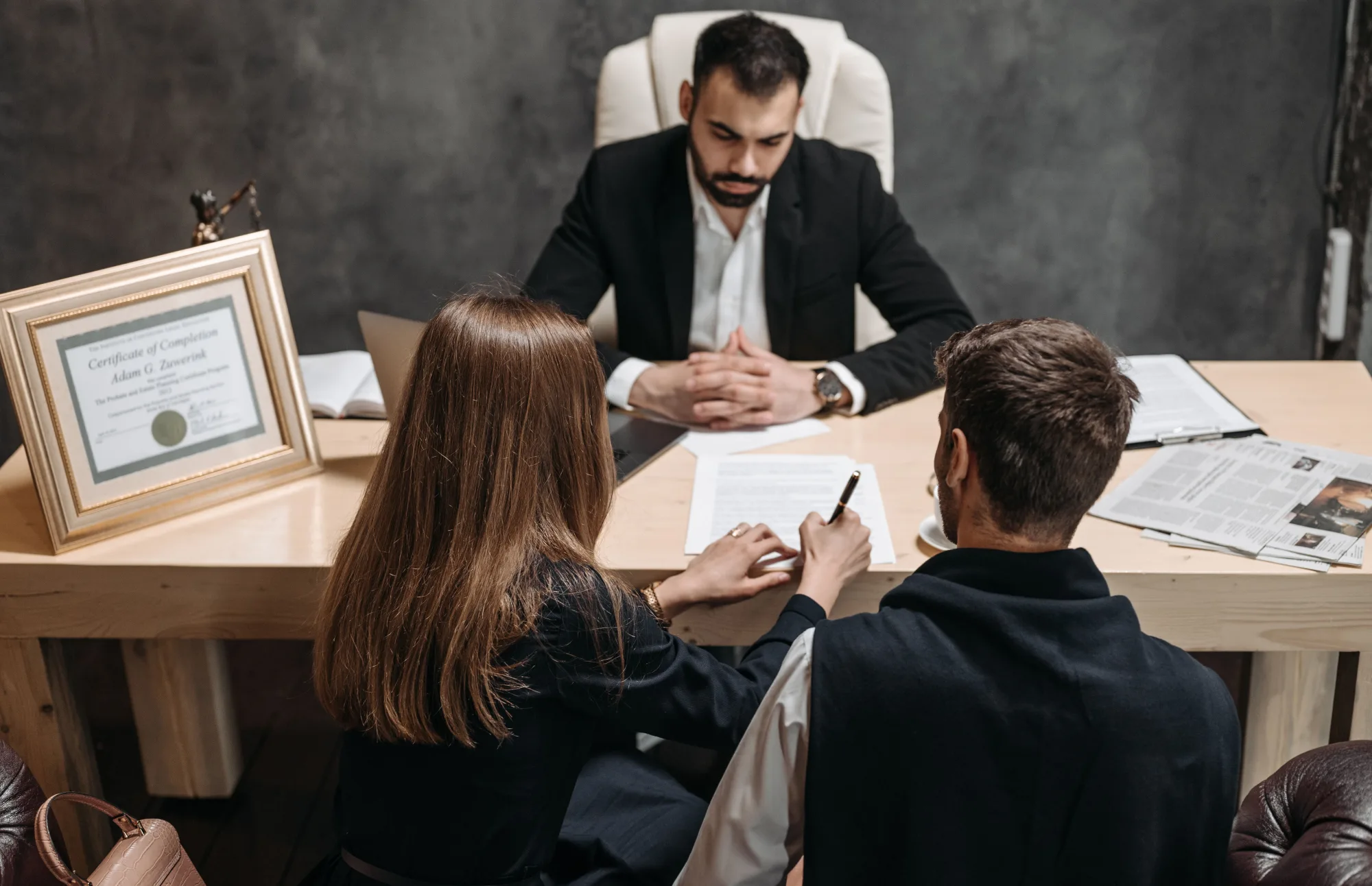 Ein Jurist bespricht Dokumente mit zwei Personen im Büro