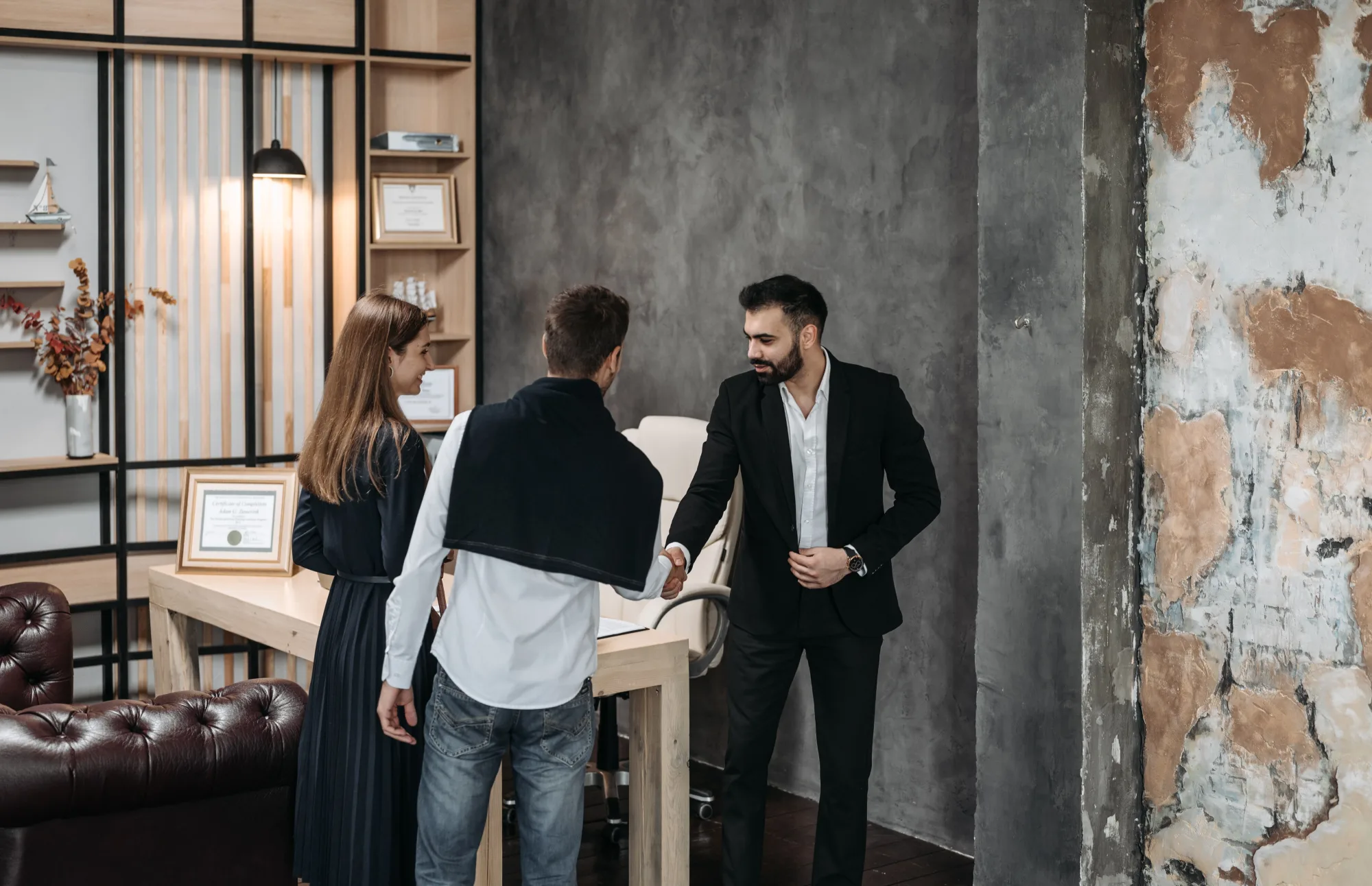 Berater bespricht mit zwei Kunden Unterlagen in einem modernen Büro