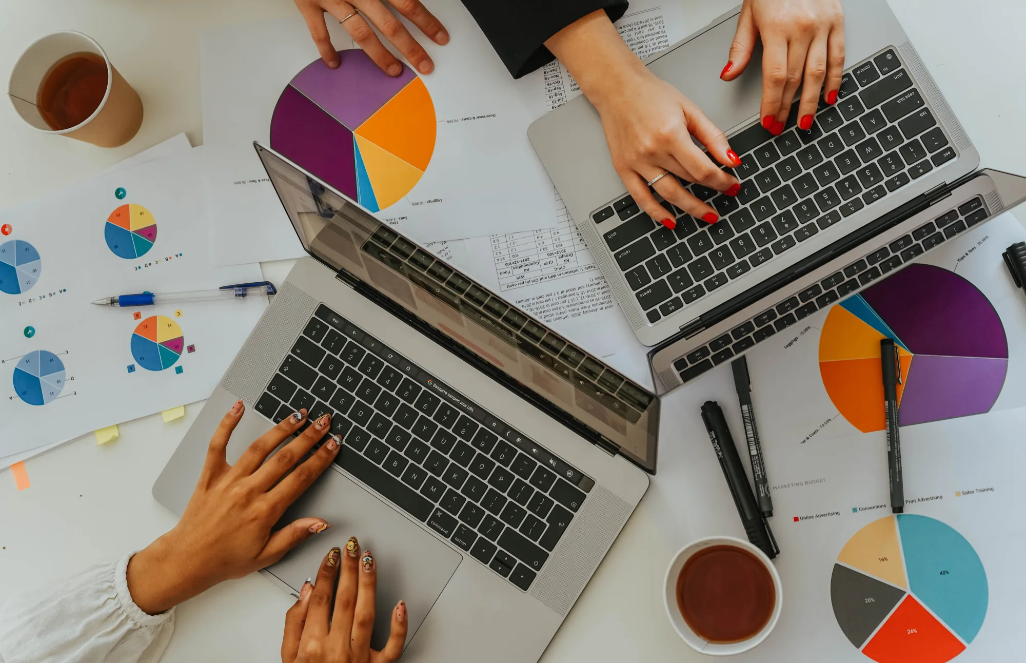 Ein Team arbeitet mit Kreisdiagrammen und Laptops an einem Tisch