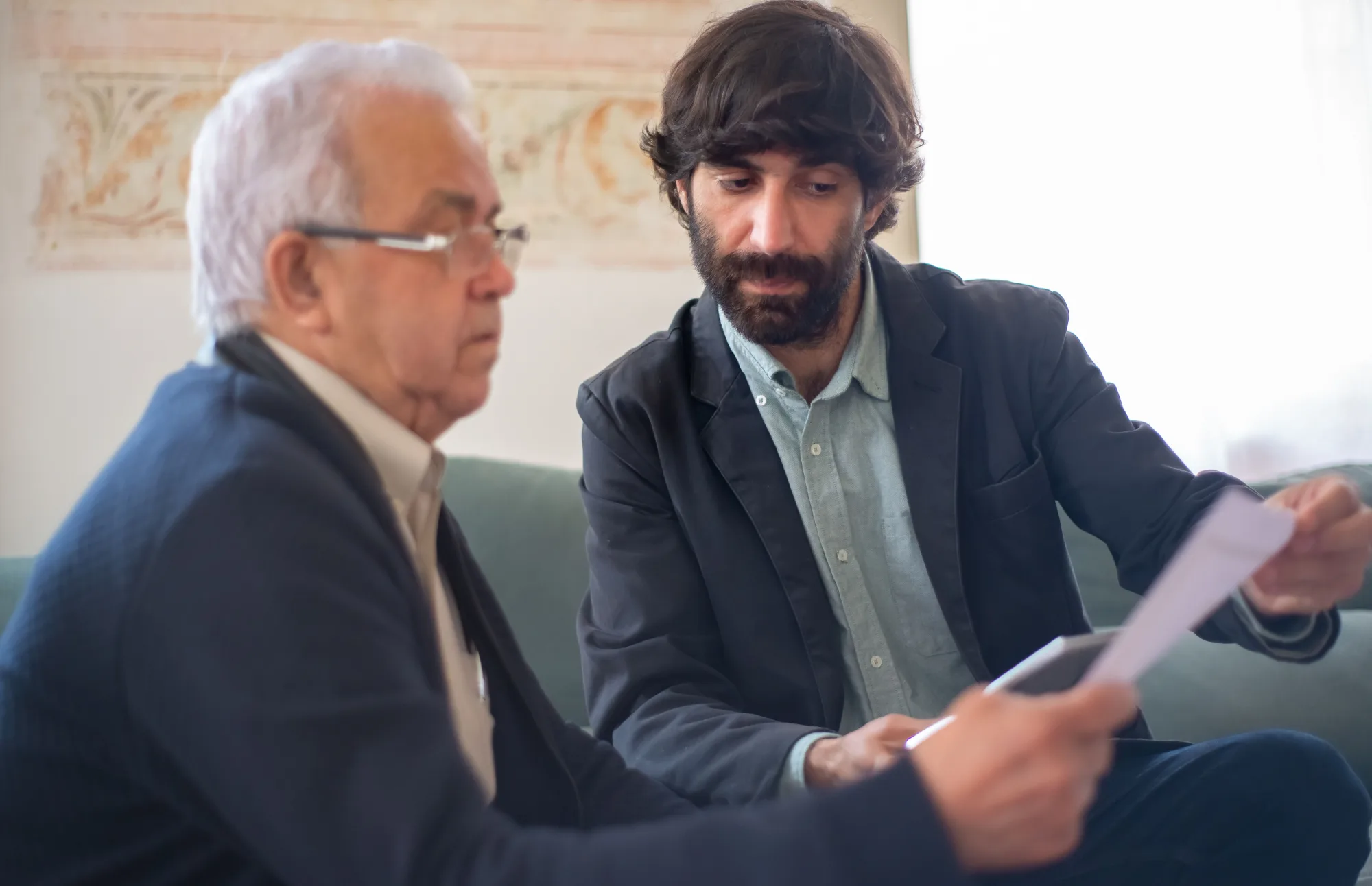 Zwei Männer vergleichen Unterlagen bei einem Beratungsgespräch