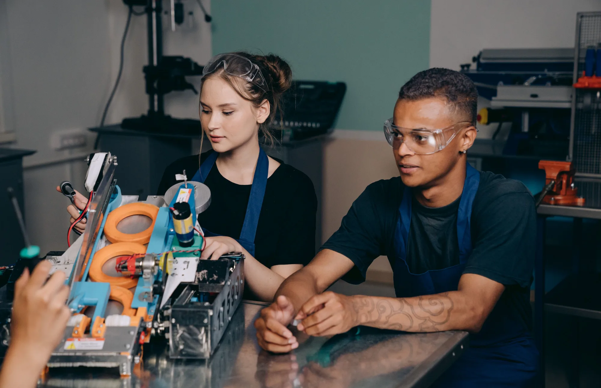 Zwei Fachkräfte arbeiten gemeinsam an einer automatisierten Maschine