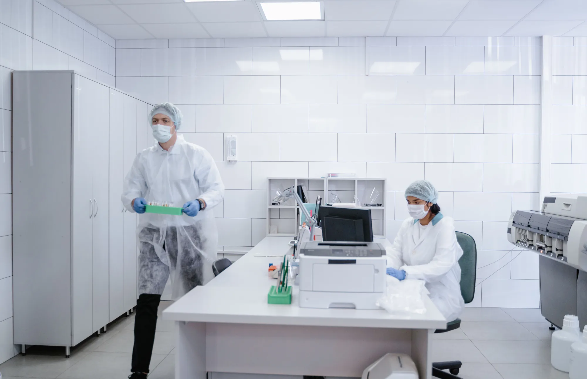 Zwei Forschende arbeiten in Schutzkleidung in einem modernen Labor.